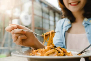 A lady enjoying a plate of handmade pasta in Singapore.