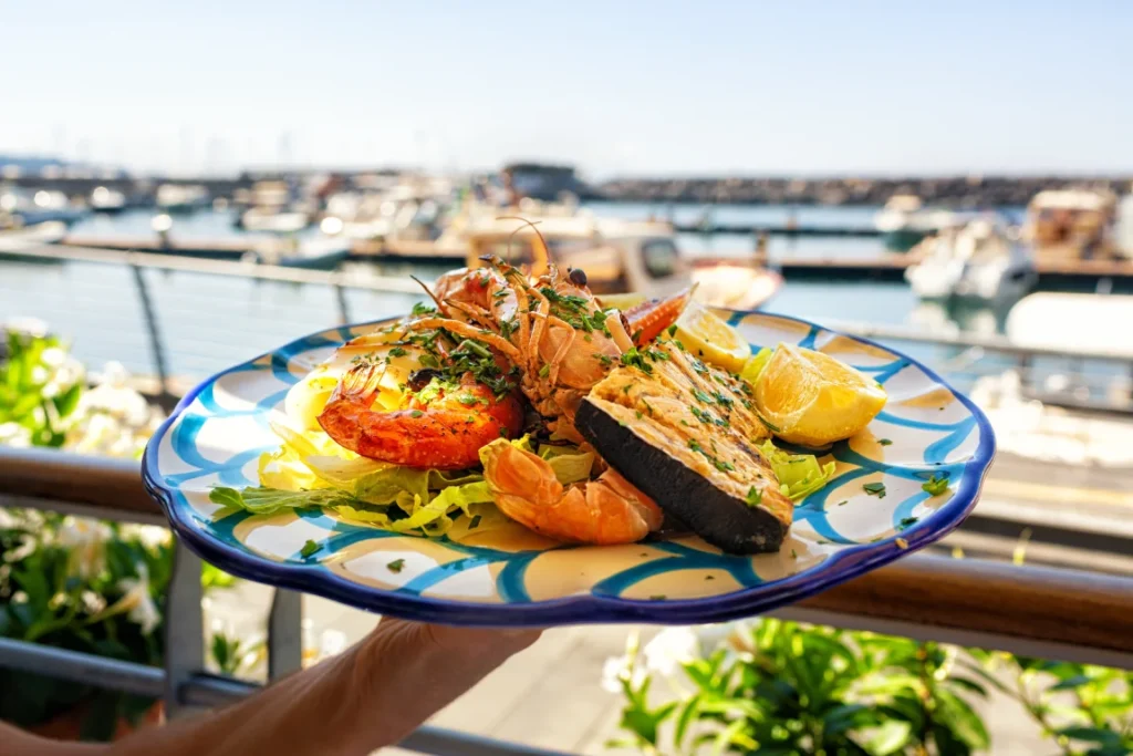 Seafood platter with grilled prawns and fish served with lemon and greens — coastal-style Italian food in Singapore.