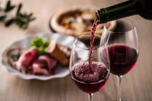 Wine being poured on into two wine glasses, indicative of a romantic date at an Italian restaurant in Singapore