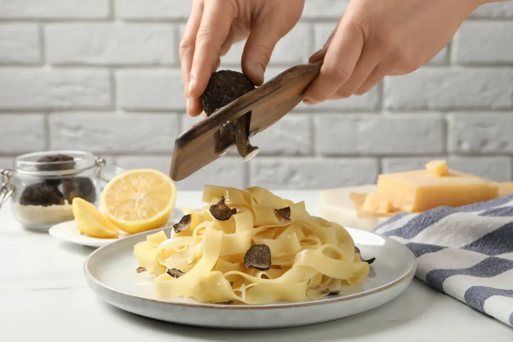Truffle being grated over a plate of truffle pasta in Singapore.