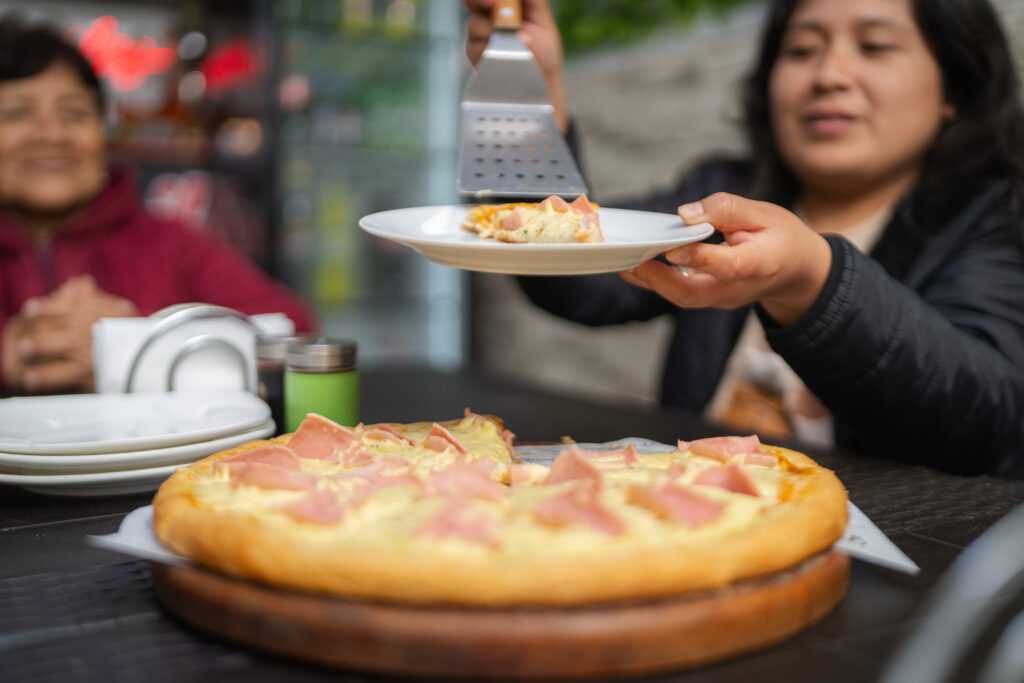 a family member getting a slice of pizza and enjoying italian cuisine in Singapore