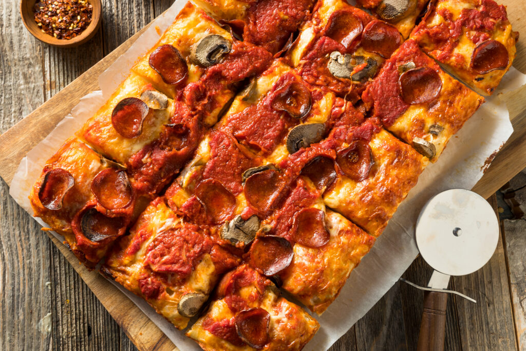 slice detroit pizza on a wooden tray, ready for delivery in Singapore