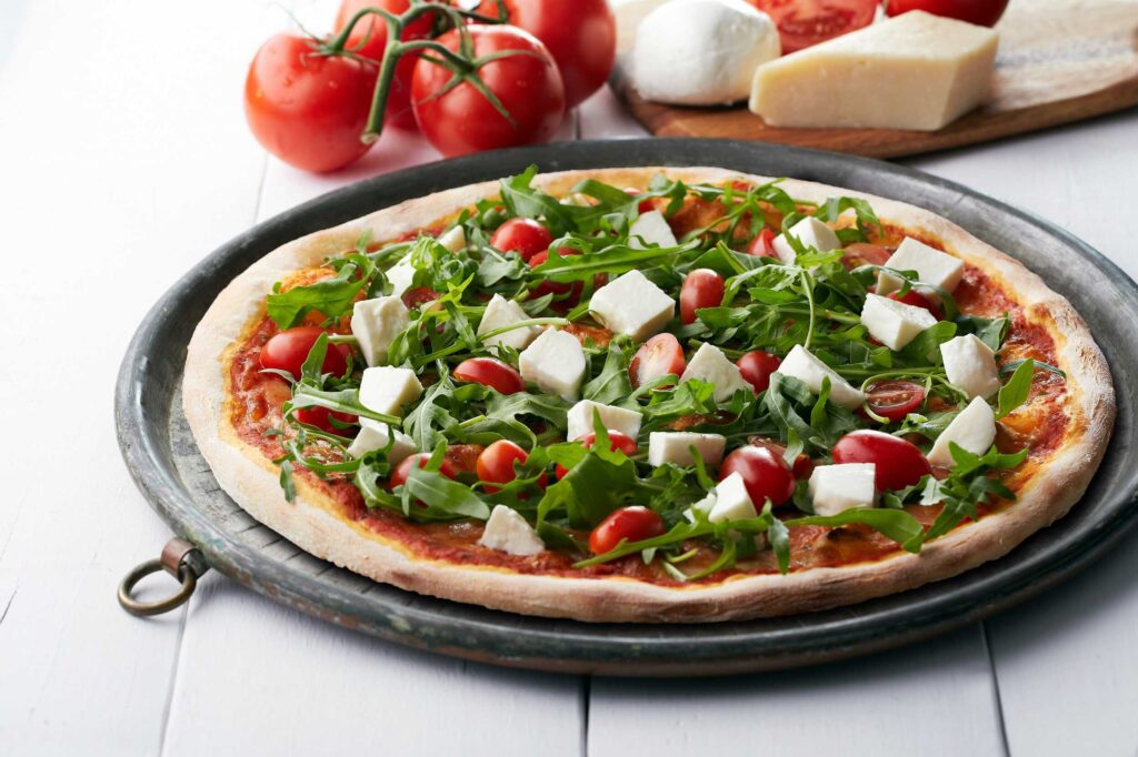 vegetarian pizza with mozzarella cheese, tomatoes, and herbs