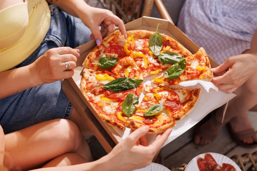 group of friends sharing fresh pizza